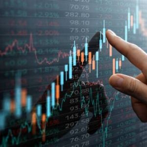 Finger pointing at stock market data display.