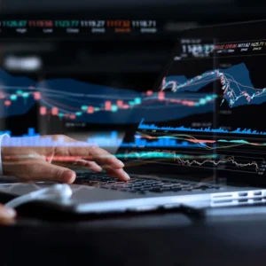 Trader monitoring market trends on laptop screen.